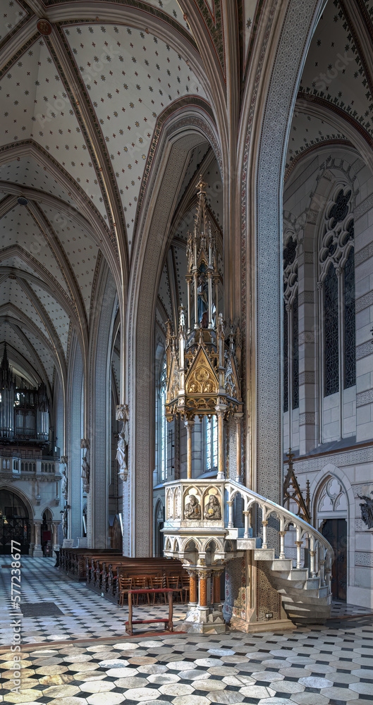 A pulpit in a church with an organ in the background.