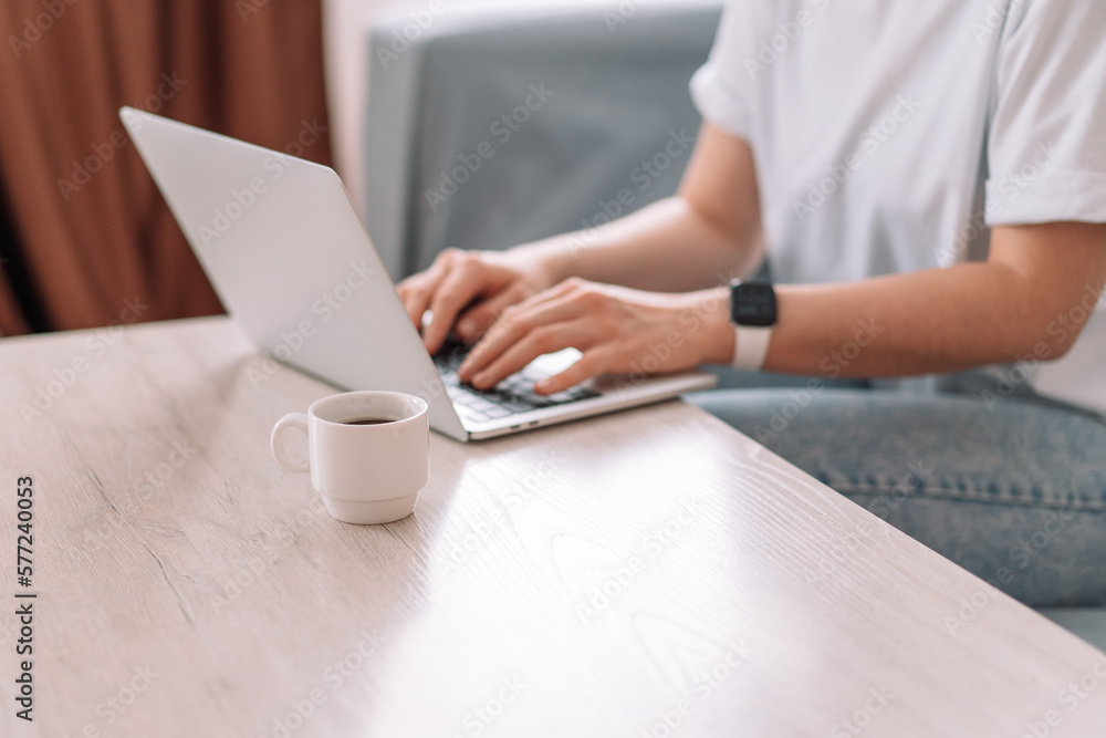 Lady working on a laptop at a table and a cup of coffee. Lady working on a laptop at a table and a cup of coffee.