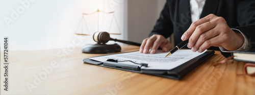 Copy space, panorama, banner, Asian female lawyer or lawyer using pen to check business information and details. Business venture acknowledgment signing documents at the desk in her office.