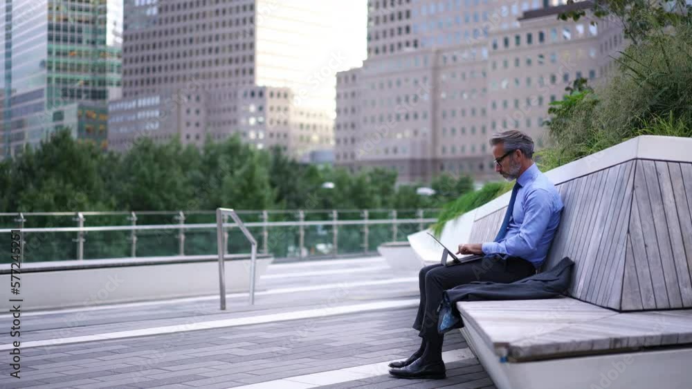 Time lapse effect, Successful Mature businessman in blue shirt and suit sitting on bench while typing text for email on touch pad. Caucasian entrepreneur in stylish eye glasses using tablet for work Time lapse effect, Successful Mature businessman in blue shirt and suit sitting on bench while typing text for email on touch pad. Caucasian entrepreneur in stylish eye glasses using tablet for work