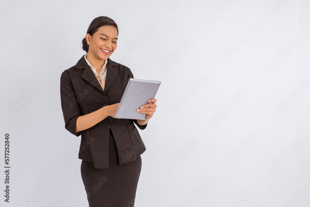 beautiful woman in formal outfit standing with smile while using the digital tablet on isolated background beautiful woman in formal outfit standing with smile while using the digital tablet on isolated background