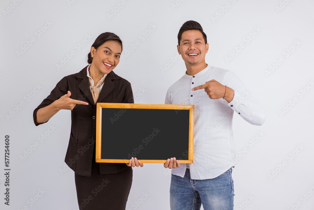 asian couple holding the blackboard together with pointed finger on isolated background asian couple holding the blackboard together with pointed finger on isolated background