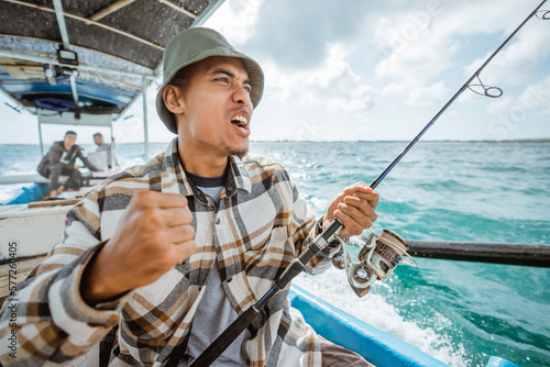 an angler's happy expression when the hook is eaten by a fish while fishing at sea