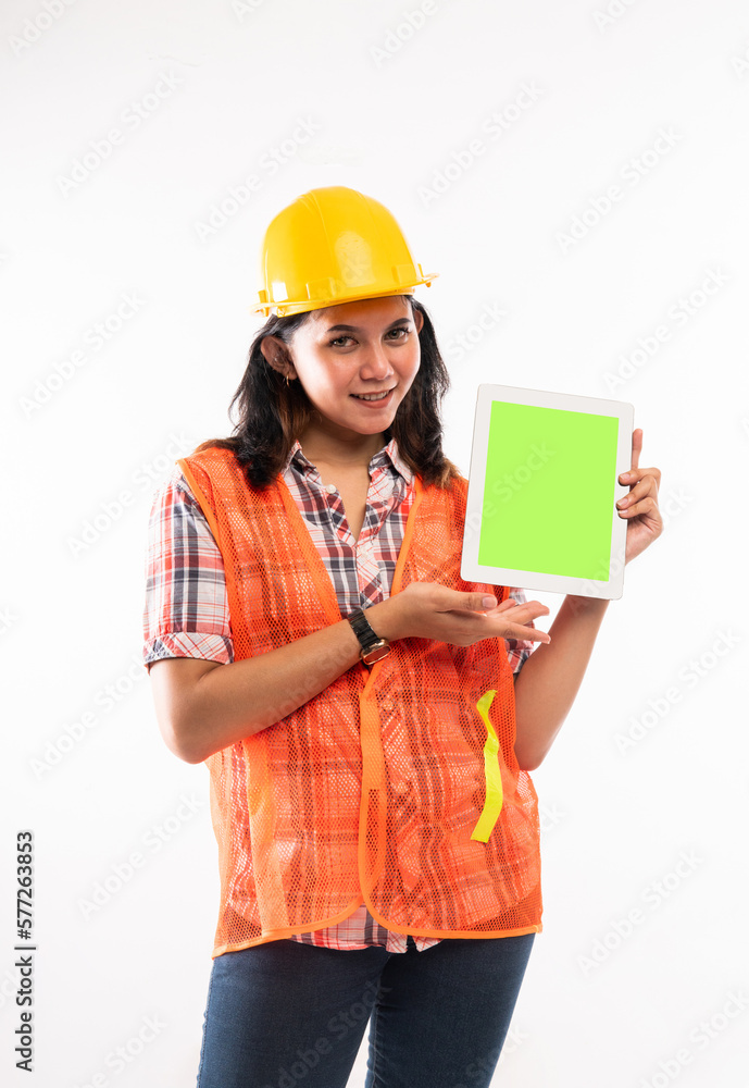 a beautiful architect in safety waistcoat standing with smile and showing the digital tablet with green screen on isolated background a beautiful architect in safety waistcoat standing with smile and showing the digital tablet with green screen on isolated background
