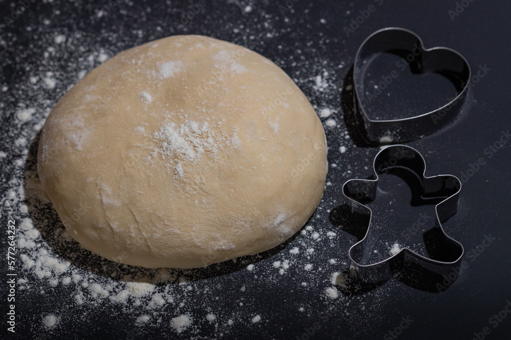 raw homemade dough against a dark background with cutters, cookie dough, raw homemade dough against a dark background with cutters, cookie dough,