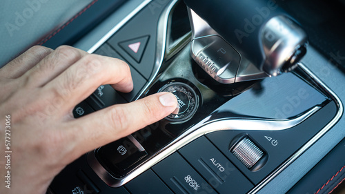 Action of a driver is pressing on the engine start button to starting the car. Close-up and selective focus.