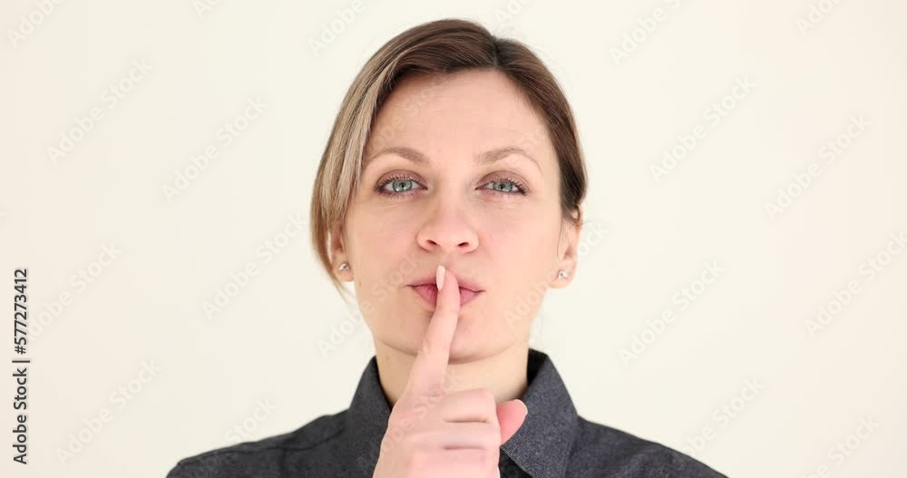 Beautiful business woman makes silent gesture with finger on her lips Beautiful business woman makes silent gesture with finger on her lips