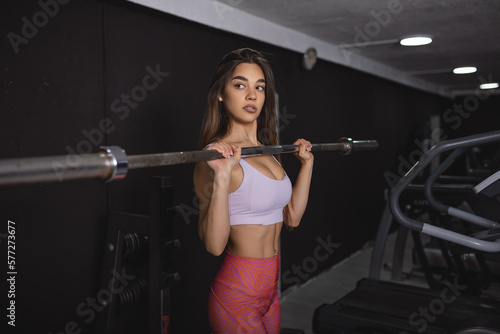 Beautiful strong sexy athletic muscular young caucasian fit woman workout training in the gym on diet pumping up muscles and posing bodybuilding health care and fitness body bar concept