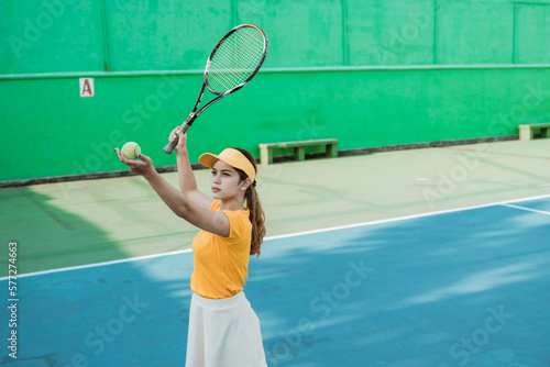 female tennis player will serve holding the ball with racket to hit on the tennis court © Odua Images