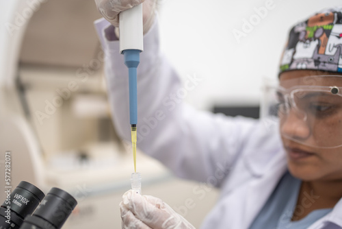 Female laboratory technique  placing a biological sample into a test tube