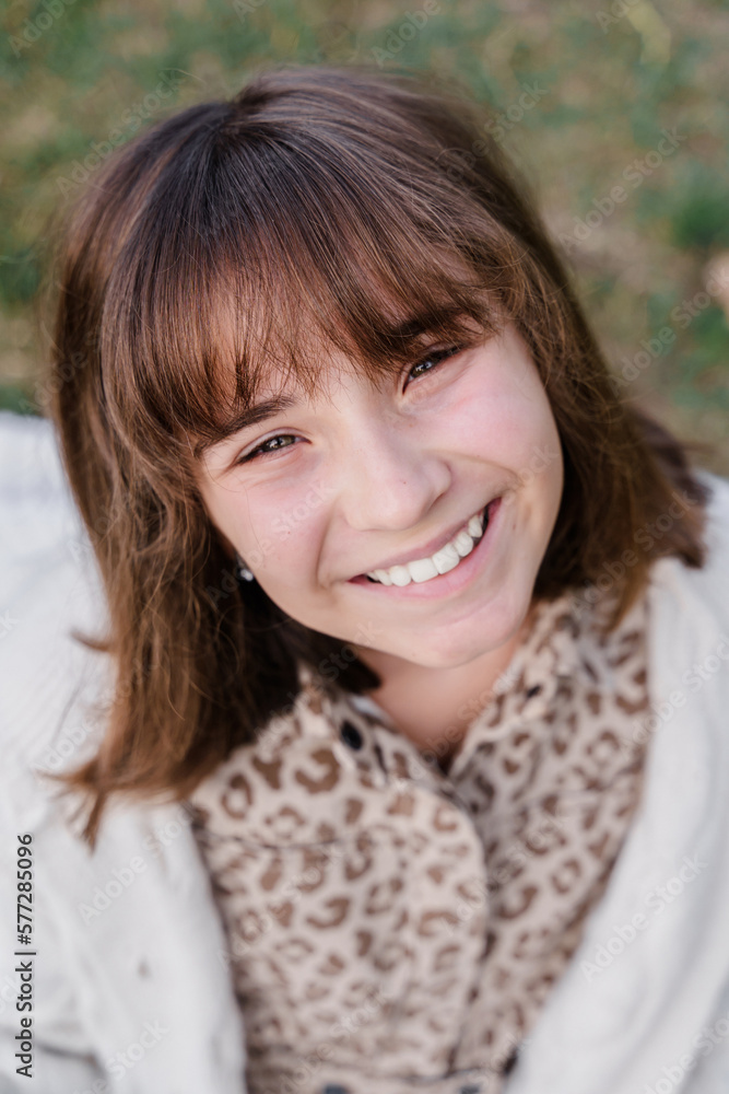 Vertical portrait of a smiling Caucasian teenage girl 12 years old