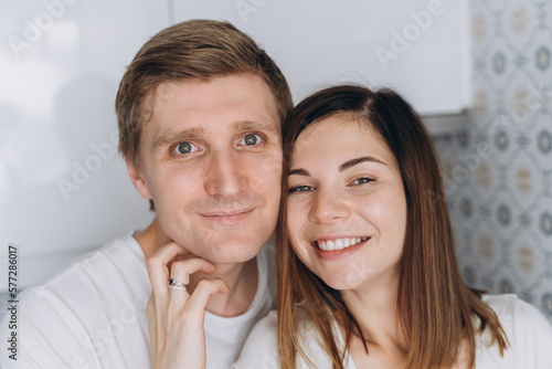 Close-up of a smiling couple of lovers on a white kitchen