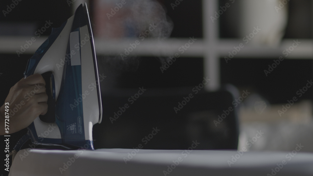 Foto de Selective focus of female hand irons white clothes with steam