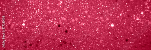 Abstract blurred red background with shine diamond particles, magic glitter banner with copy space for festive design.Trendy color 2023 Viva Magenta