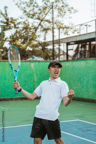 male tennis players get excited while getting points while playing on tennis court © Odua Images