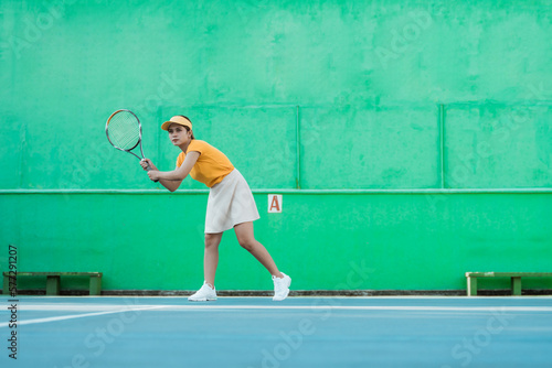 female tennis player ready to receive ball while holding racket on tennis court
