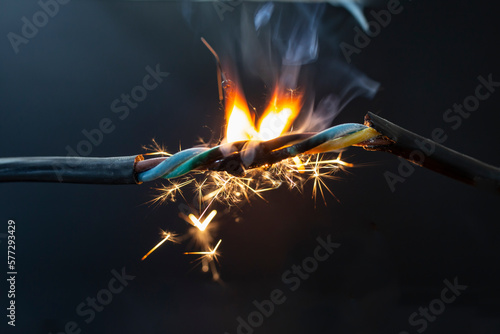Fotografiet flame smoke and sparks on an electrical cable, fire hazard concept