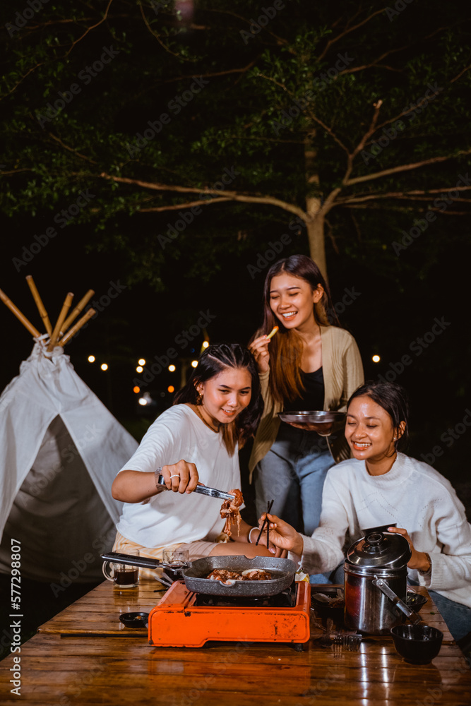 a group of women enjoying their grilled beef with the french fries or a bowl of rice while camping at the camp site