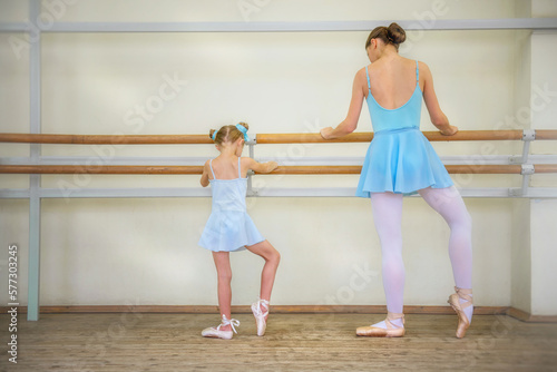 Little girl ballerina. Choreographer and student. Ballerinas. Girl and ballet teacher. The girl is learning to dance. Ballerinas on pointe. Ballerinas in tutus. Ballet and dance training. Dancers at t