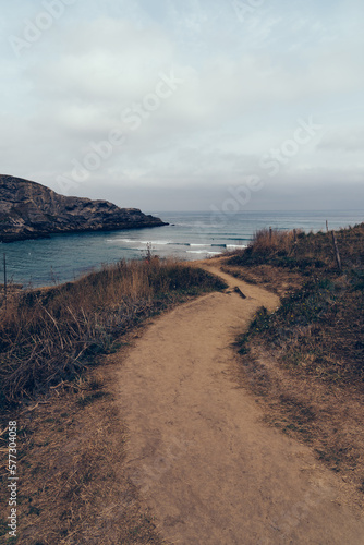 Cliffs surrounding the Beach of Antuerta in Ajo, Trasmiera, Cantabria, Spain. The coast is traversed by a hiking trail that runs through stunning scenery.