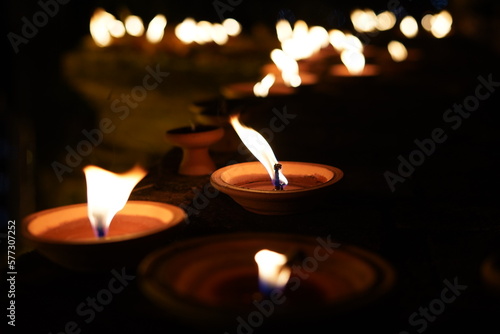lighing candle small bowls to worship and respect individual religious believe for local way of life, candle flame as warm wish giving light through night time. photo