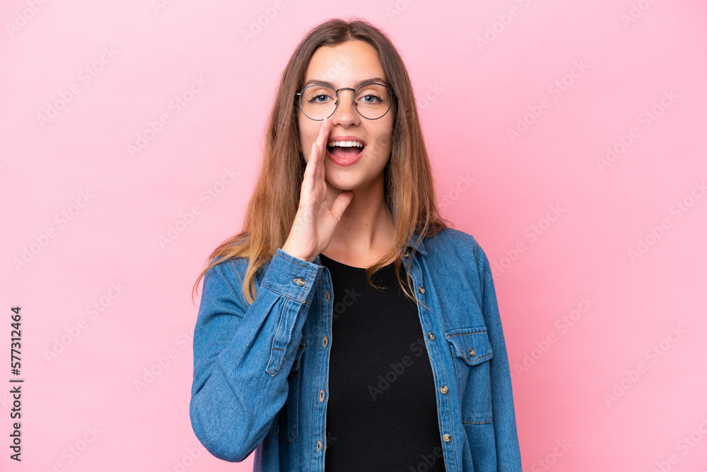 Young caucasian woman isolated on pink background shouting with mouth wide open Young caucasian woman isolated on pink background shouting with mouth wide open