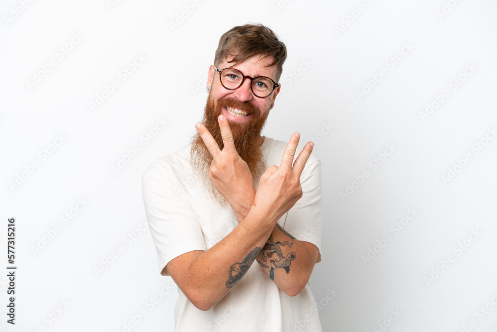 Redhead man with long beard isolated on white background smiling and showing victory sign Redhead man with long beard isolated on white background smiling and showing victory sign