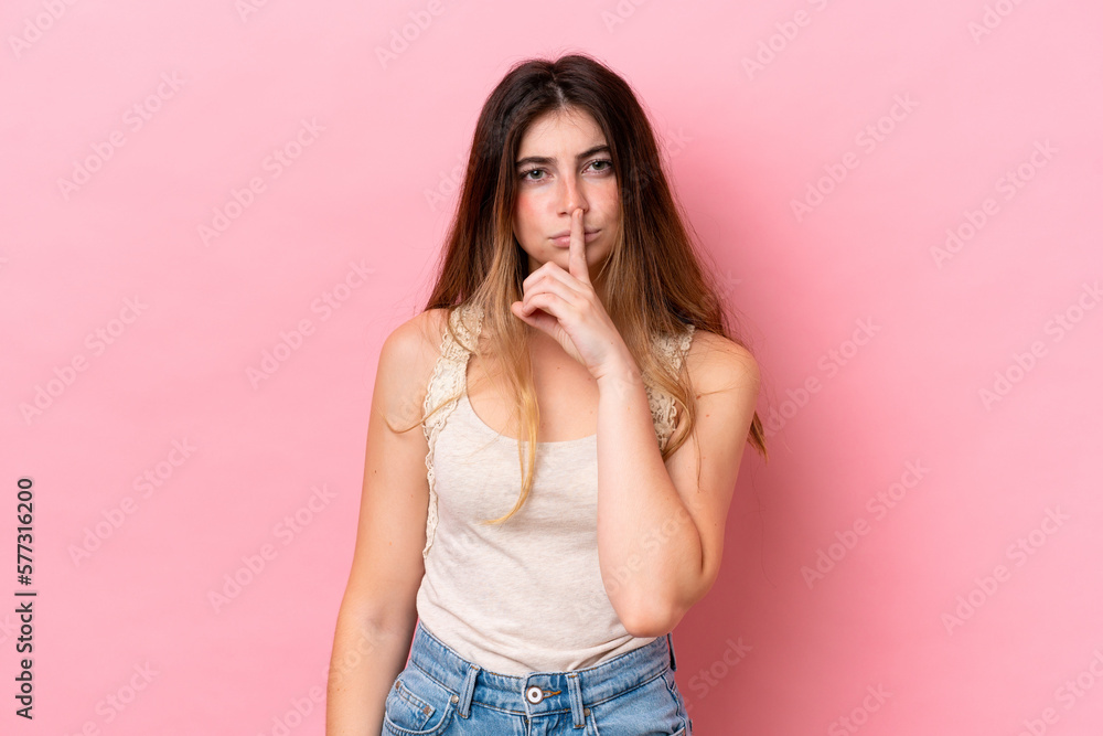 Young caucasian woman isolated on pink background showing a sign of silence gesture putting finger in mouth Young caucasian woman isolated on pink background showing a sign of silence gesture putting finger in mouth