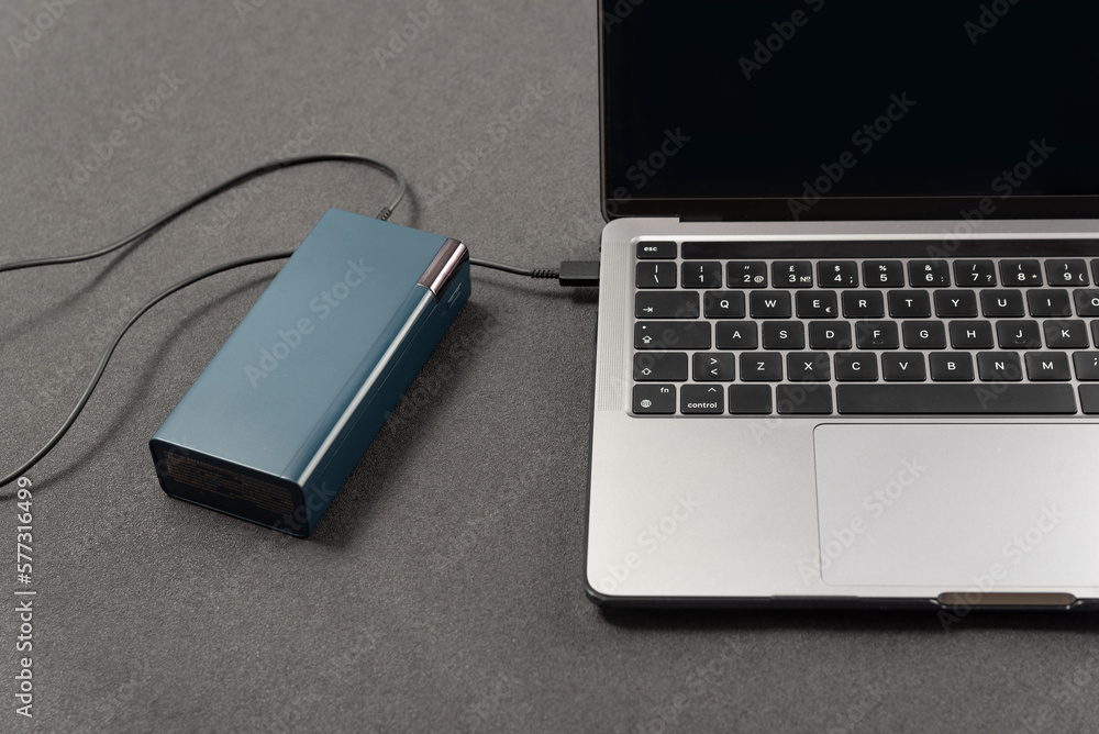 Top view laptop is connected by cord to an external battery. Laptop is