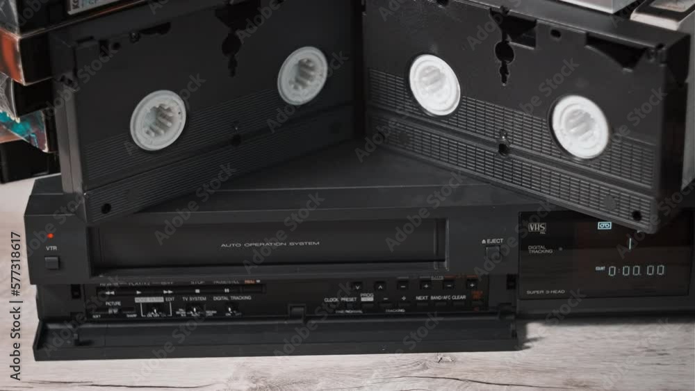 Vidéo Stock Male hand inserts VHS cassette into a VCR Video recorder. Black vintage videotape