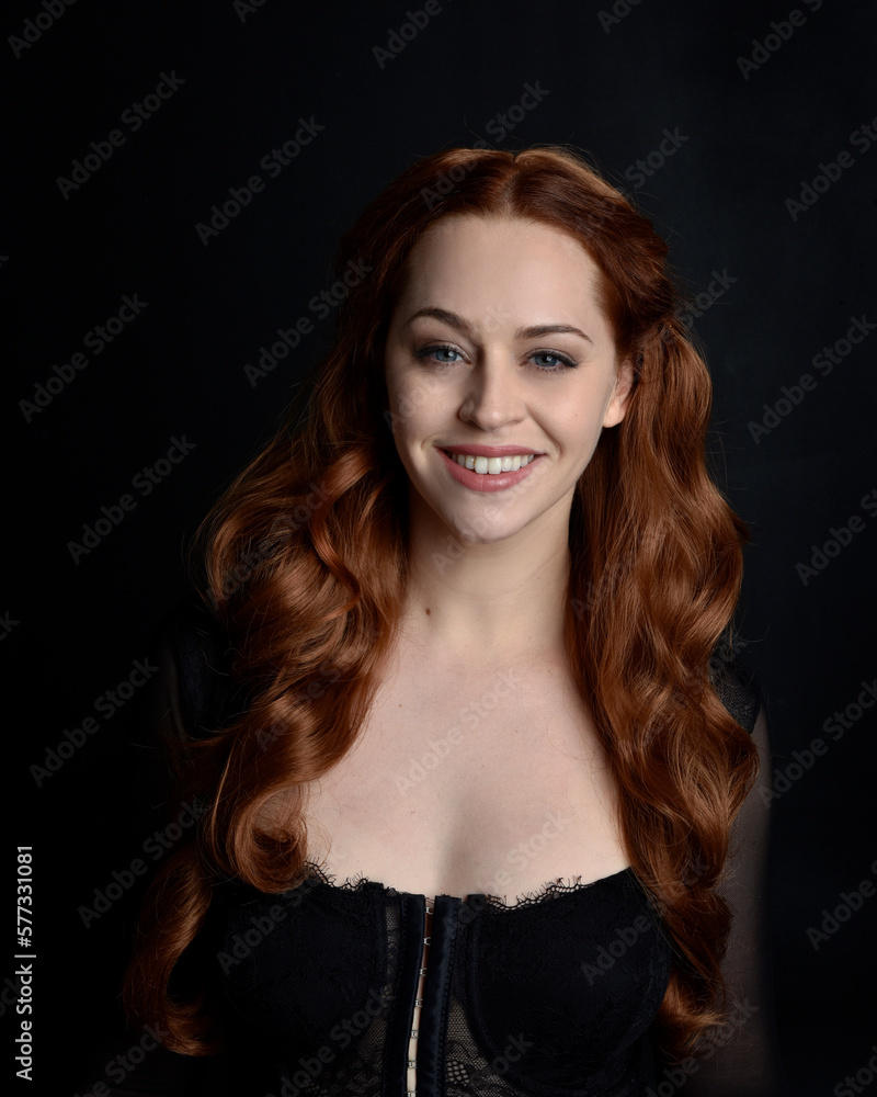 close up portrait of beautiful woman with long red hair wearing sheer corset top. variety of facial expressions, Isolated on dark studio background with moody silhouette lighting. close up portrait of beautiful woman with long red hair wearing sheer corset top. variety of facial expressions, Isolated on dark studio background with moody silhouette lighting.