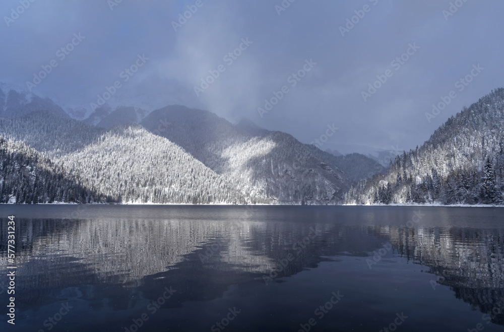Beautiful winter landscape with mountain Ritsa lake and snow-covered trees along the shore. Great natural background with copy space for your design. Beautiful winter landscape with mountain Ritsa lake and snow-covered trees along the shore. Great natural background with copy space for your design.
