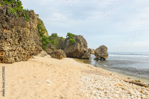 Tropical rocky beach with white sand and cliffs and blue sky with clouds on Sunny day. Summer tropical landscape, panoramic view. travel tourism wide panorama background concept. 