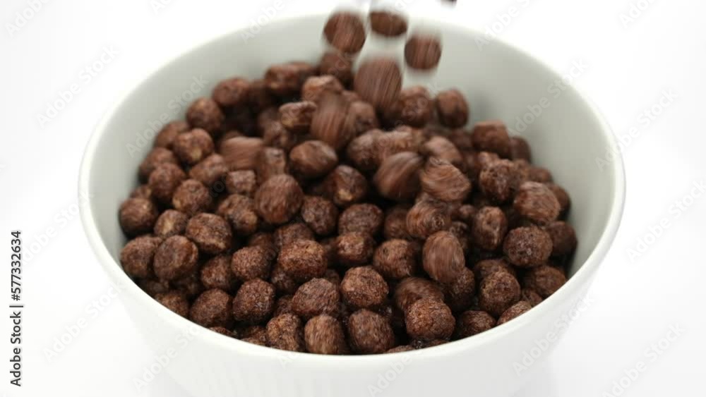 Chocolate breakfast cereal falling in bowl, close up Chocolate breakfast cereal falling in bowl, close up
