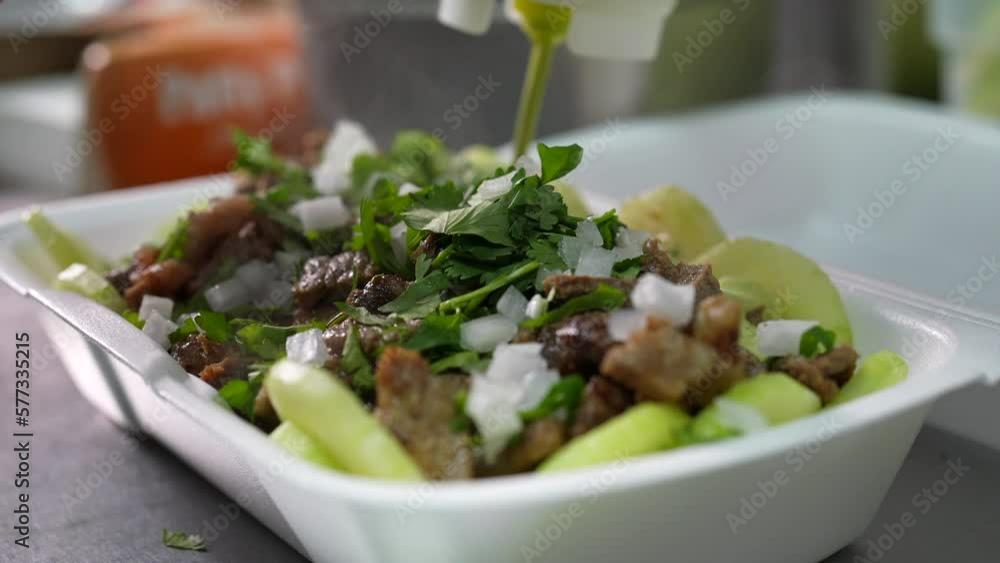 Squirting avocado salsa sauce on a keto bowl - food truck series Squirting avocado salsa sauce on a keto bowl - food truck series