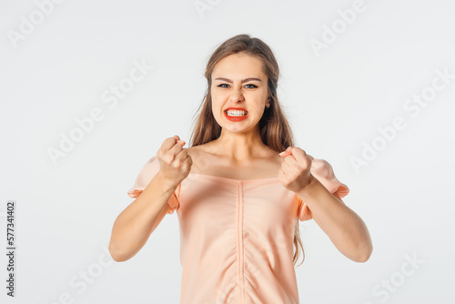 Pissed-off girl gesticulating with her hands, stands over white background. Distressed and irritated female squeeze hands in fists losing patience, boiling from annoyance