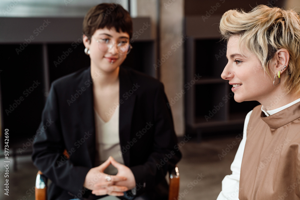 Two female colleagues having discussion during business meeting in conference room