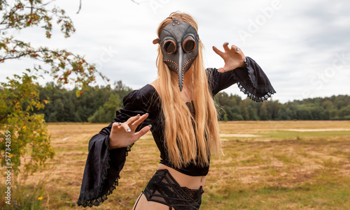 Фотография Intriguing portrait of woman in plague mask with forest background