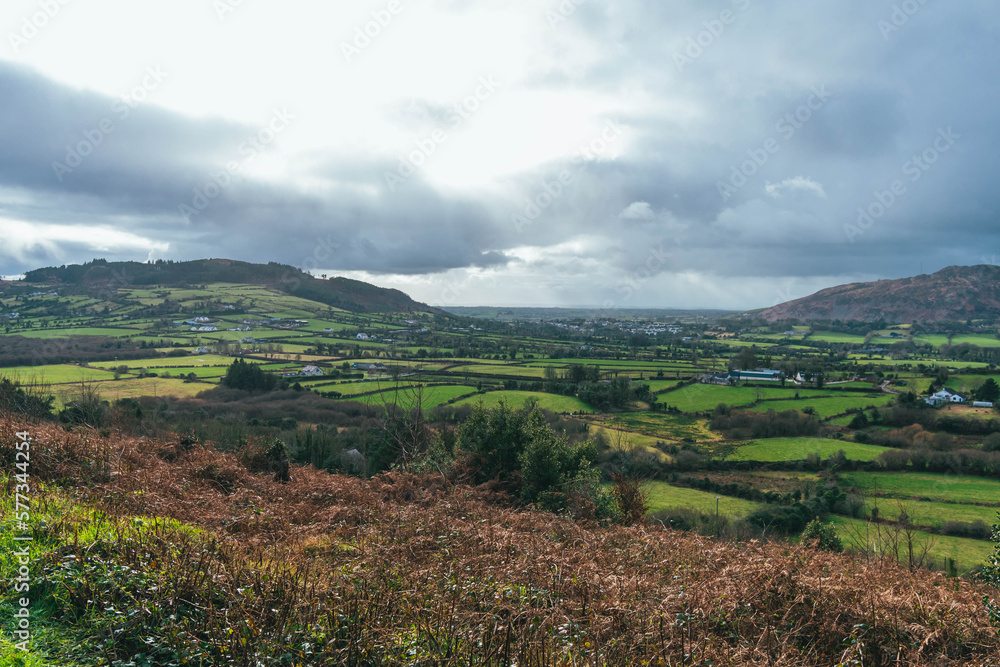 Grey cloudy sky, with rolling green hills and vegetation, Slieve Gullion, Co. Armagh,  Ring of Gullion, Northern Ireland, showing farmland fields and trees