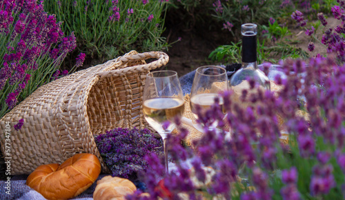 wine, fruits, berries, cheese, glasses picnic in lavender field. Selective focus