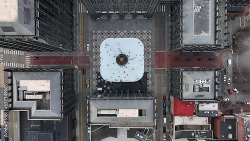 Top down aerial shot of ice skaters in urban city square. Beautiful winter time tradition, ice skating rink in America.