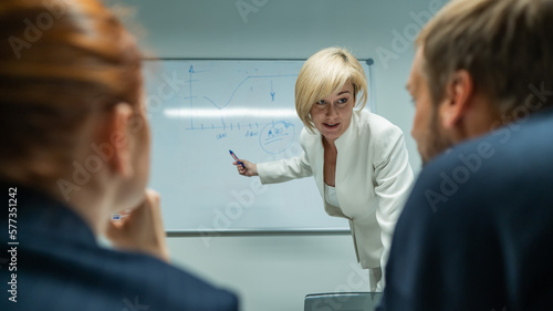 Caucasian woman blonde leads a presentation for colleagues. 
