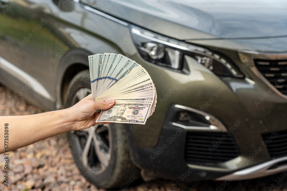 Person with money in the hand stands front car. Insurance, loan and buying car concept Person with money in the hand stands front car. Insurance, loan and buying car concept
