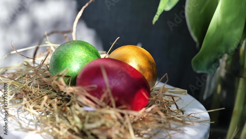 Obraz na płótnie Easter colorful eggs rotate in nest with hey outdoor in sunny warming day. w salonie