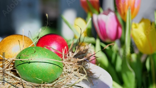Obraz na płótnie Easter colorful eggs outdoor in sunny warming day with beautiful flowers w salonie