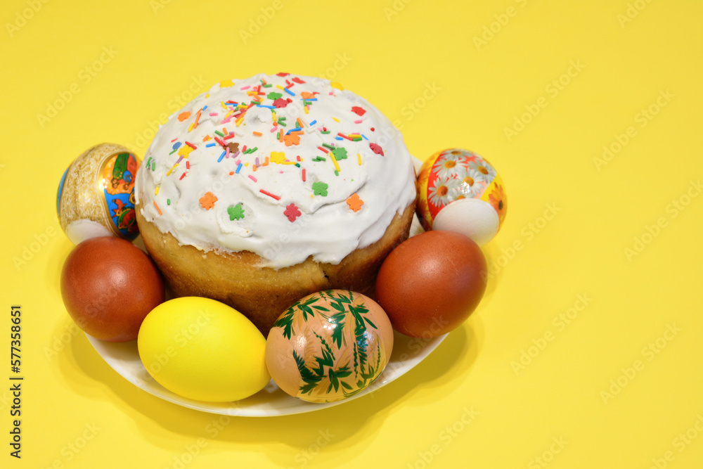 Fototapeta premium A plate of colorful eggs and a cake with sugar sprinkles isolated copy space