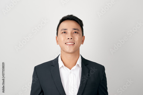 portrait of young handsome southeast Asian businessman looking up on white background