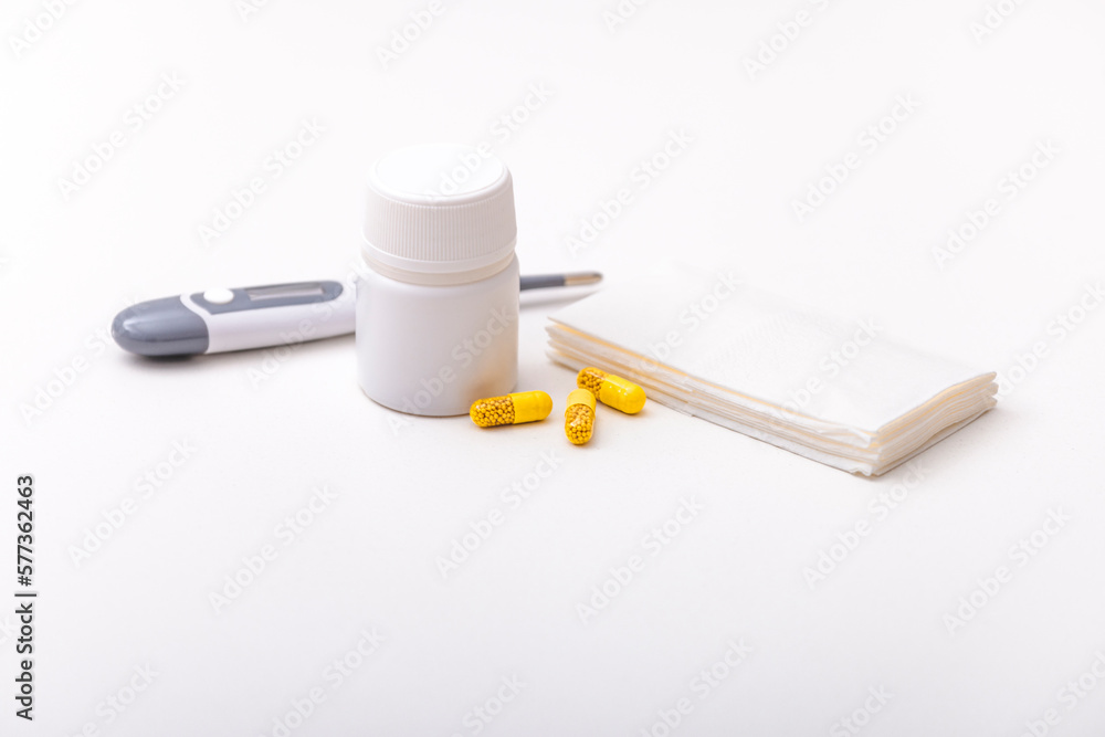 Thermometer, pills, vitamins and tissues on a white background. Home pharmacy Thermometer, pills, vitamins and tissues on a white background. Home pharmacy