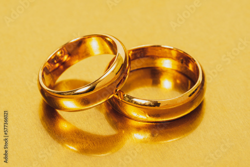 Gold wedding rings on a metal surface