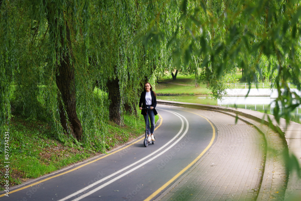 custom made wallpaper toronto digitalA young woman walks along the path for an electric scooter in the city. Modern modes of transport